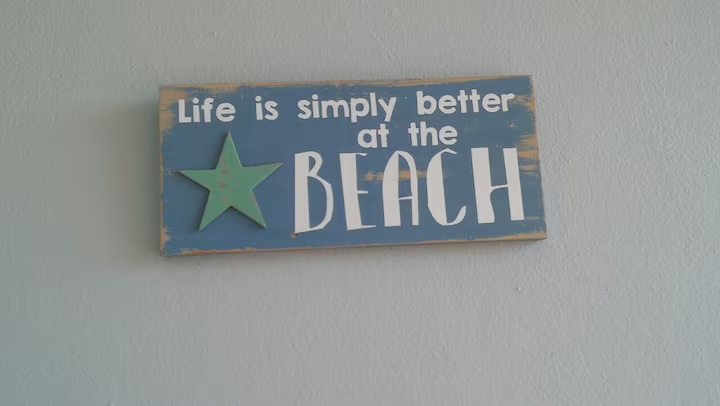 A painted sign reading life is simply better at the beach