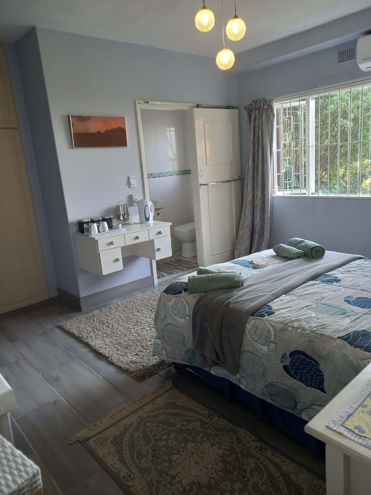 The double bedroom with pendant lights, air conditioning and a tea and coffee station